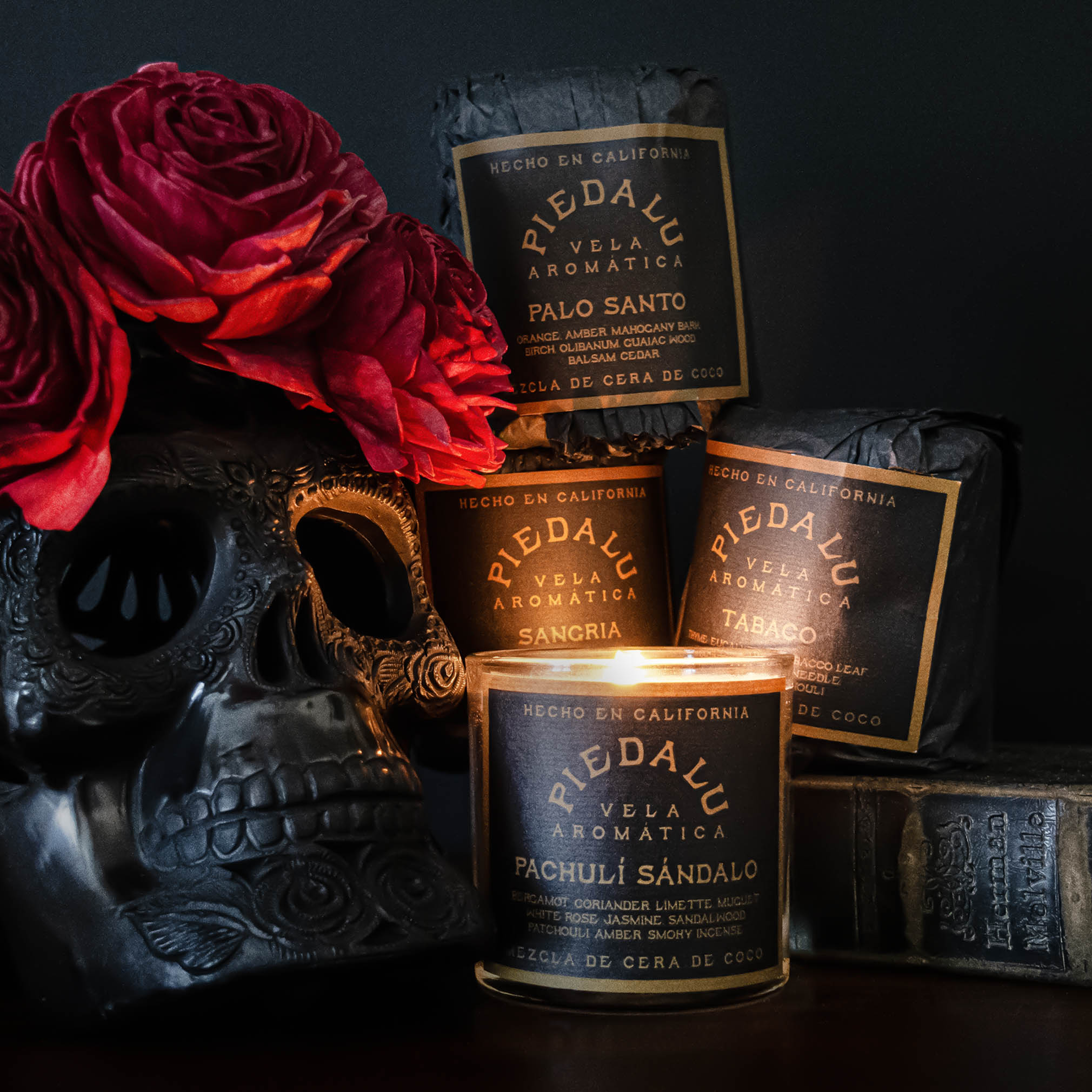Collage of various Piedalu scented candles with a black skull and red flowers